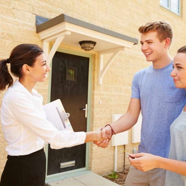 A millennial couple talking with their real estate agent about selling their home
