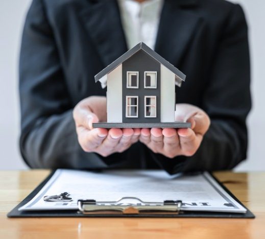 A financial agent holding a miniature house carefully, symbolizing Private mortgage insurance