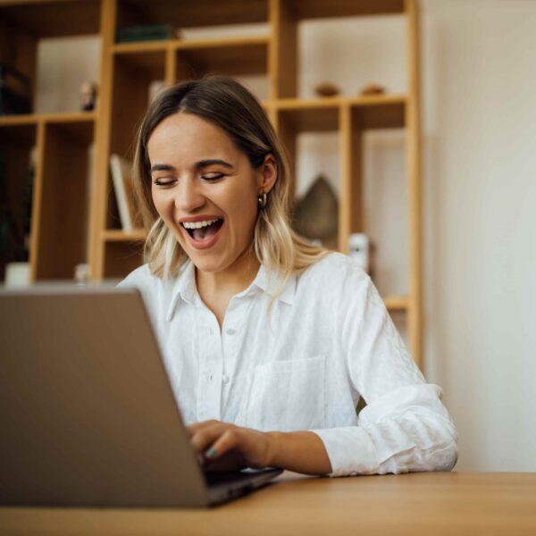 happy self employed homeowner checks her approved home equity loan application on her laptop