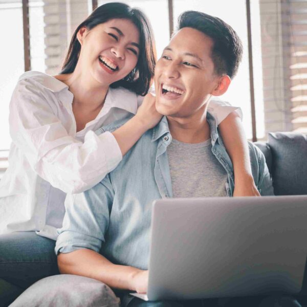 happy homeowners couple checking laptop on how can they use their HELOC funds