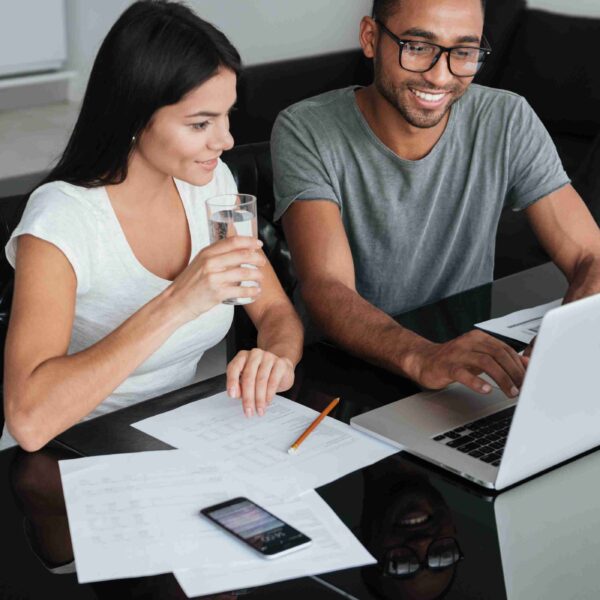 happy homeowners couple consolidating unsecured debt with their home equity using laptop