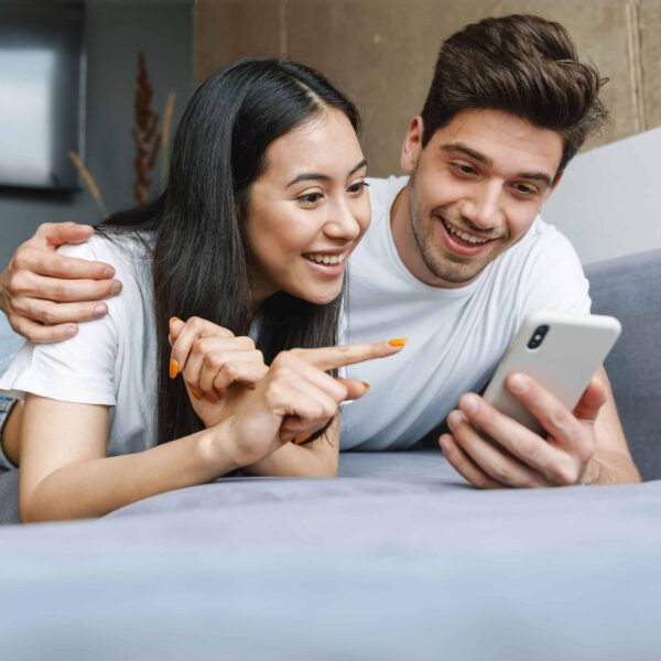 happy homeowner couple checking housenumbers app on mobile